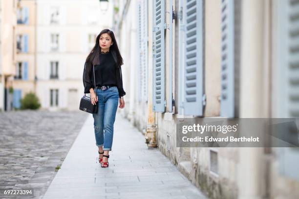May Berthelot, fashion blogger and Head of Legal at Videdressing.com, wears a Harpe black lace top, The Kooples blue denim cropped jeans, a Gucci...