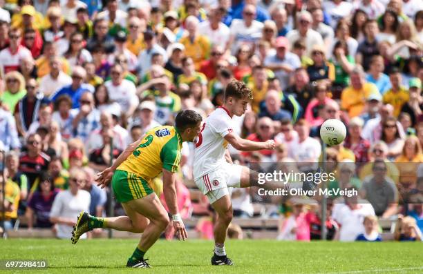 Monaghan , Ireland - 18 June 2017; Mark Bradley of Tyrone scores a point before the tackle of Paddy McGrath of Donegal during the Ulster GAA Football...