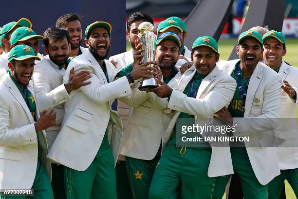 Pakistan's Sarfraz Ahmed holds the trophy as Pakistan players celebrate their win at the presentation after the ICC Champions Trophy final cricket...