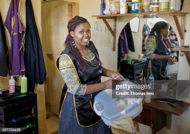 Talek, Kenya Portrait of the hairdresser Emma Kinyanjui, operator of a barber and cosmetic salon, at work on May 17, 2017 in Talek, Kenya.