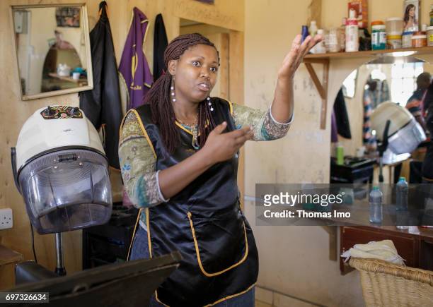 Talek, Kenya Portrait of the hairdresser Emma Kinyanjui, operator of a barber and cosmetic salon, at work on May 17, 2017 in Talek, Kenya.