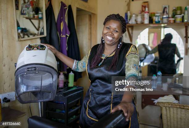 Talek, Kenya Portrait of the hairdresser Emma Kinyanjui, operator of a barber and cosmetic salon, at work on May 17, 2017 in Talek, Kenya.