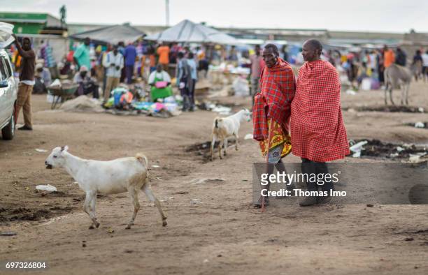 Talek, Kenya Two African men walk across a market on May 17, 2017 in Talek, Kenya.