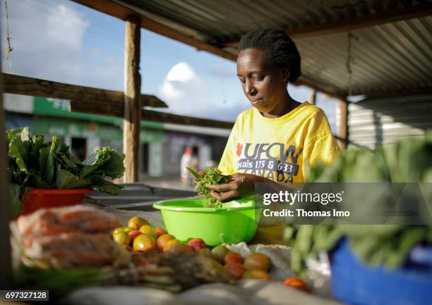 Talek, Kenya An African woman cuts herbs at a market on May 17, 2017 in Talek, Kenya.