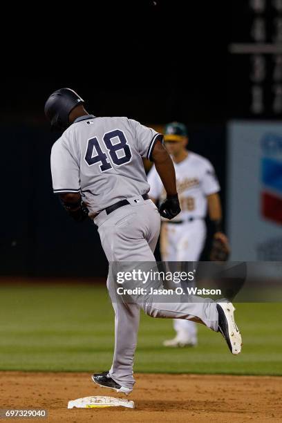 Chris Carter of the New York Yankees rounds the bases after hitting a home run against the Oakland Athletics during the eighth inning at the Oakland...