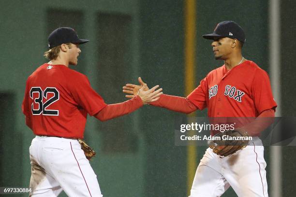 Josh Rutledge high fives Xander Bogaerts of the Boston Red Sox after their victory over the Seattle Mariners at Fenway Park on May 26, 2017 in...