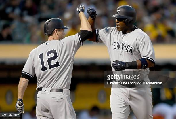 Chris Carter of the New York Yankees is congratulated by Chase Headley after Carter hit a solo home run against the Oakland Athletics in the top of...
