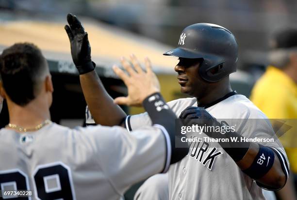 Chris Carter of the New York Yankees is congratulated by teammates after he hit a solo home run against the Oakland Athletics in the top of the six...