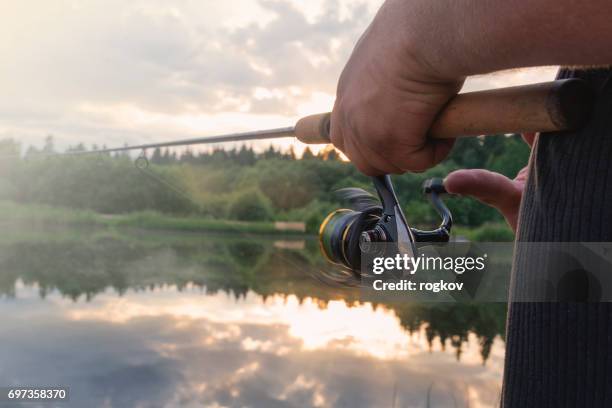 der mann fängt ein angel fisch auf einen stausee. - rod stock-fotos und bilder