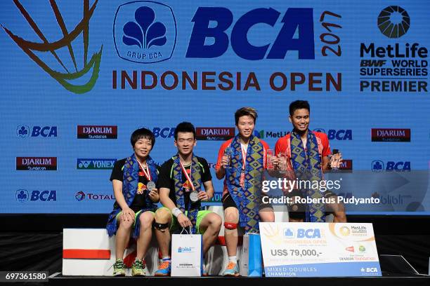 Gold medalist Tontowi Ahmad and Liliyana Natsir of Indonesia and silver medalist Zheng Siwei and Chen Qingchen of China celebrate on the podium...