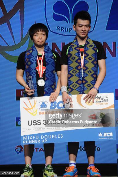 Silver medalist Zheng Siwei and Chen Qingchen of China celebrate on the podium during Mixed Double medals ceremony of the BCA Indonesia Open 2017 at...