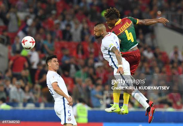 Cameroon's defender Adolphe Teikeu heads the ball with Chile's midfielder Arturo Vidal next to Chile's midfielder Francisco Silva during the 2017...