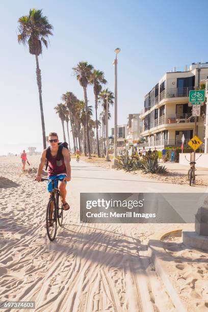 venice beach, teenage boy riding bicycle - venice california stock pictures, royalty-free photos & images