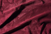 Texture of  burgundy crumpled leather close-up background
