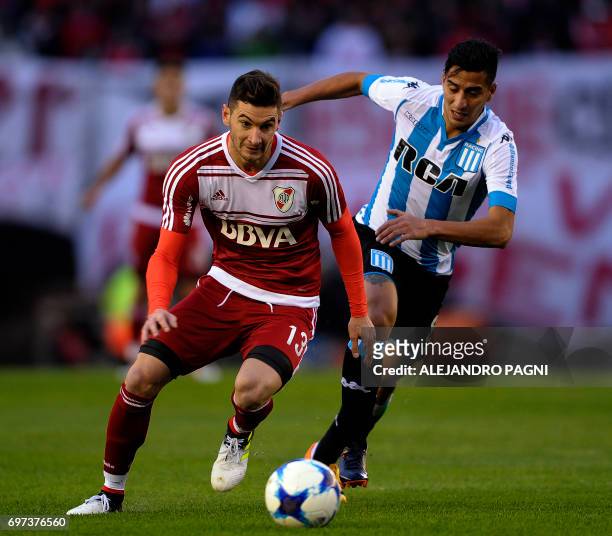 River Plate's forward Lucas Alario vies for the ball with Racing's midfielder Diego Gonzalez during their Argentina First Divsion football match at...