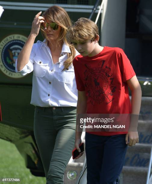 First Lady Melania Trump and son Barron walk across the South Lawn upon return to the White House on June 18, 2017 in Washington, DC. - US President...
