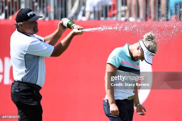 Brooke Henderson of Canada is sprayed with champagne by her father Dave Henderson during the final round of the Meijer LPGA Classic at Blythefield...