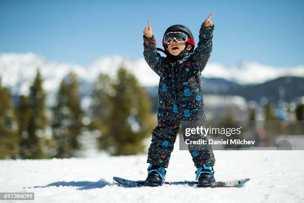 happy kid with a snowboard on top of a mountain. - ski gear stock pictures, royalty-free photos & images