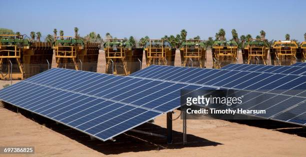 solar panels with cotton balers in the background - blythe brown stock-fotos und bilder