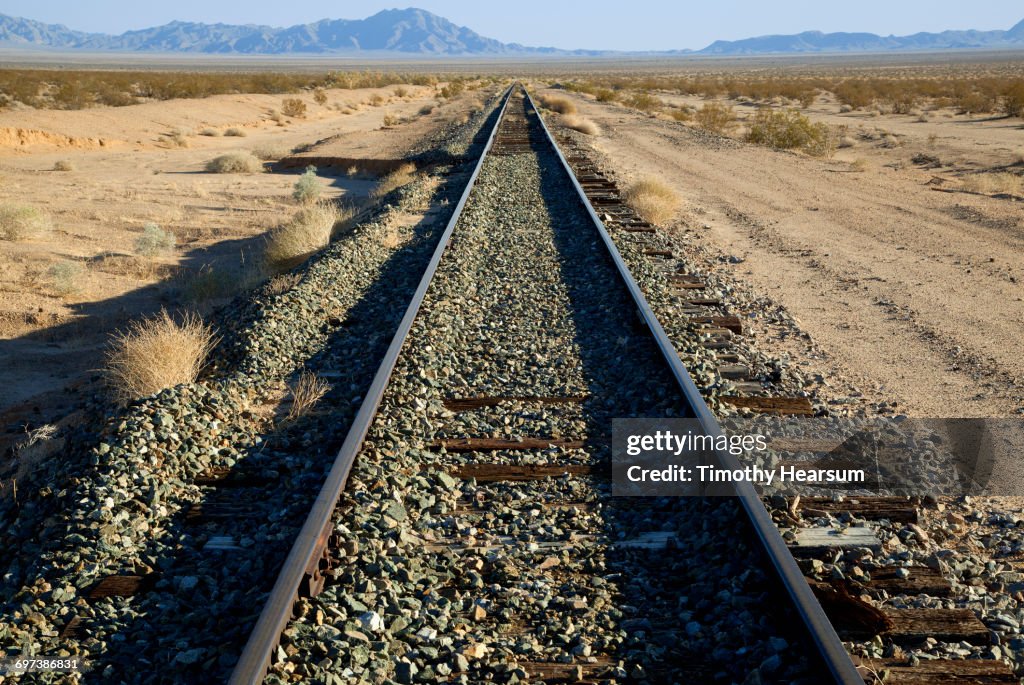 Railroad tracks passing through desert landscape