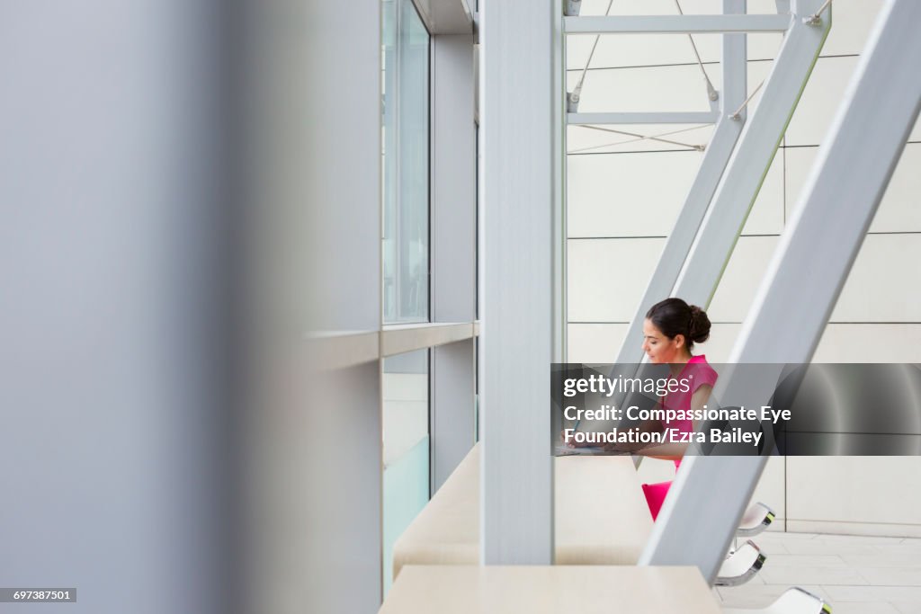 Businesswoman working in modern lobby