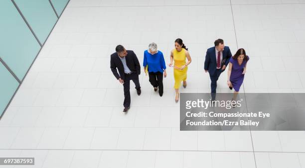 business people walking in modern lobby - cinco pessoas imagens e fotografias de stock