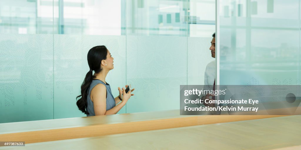 Businesswoman talking to colleague in office