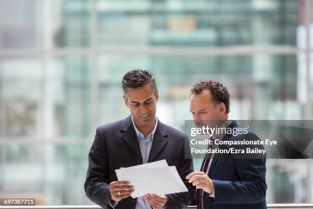 businessmen discussing project on office balcony - looking over balcony stock pictures, royalty-free photos & images