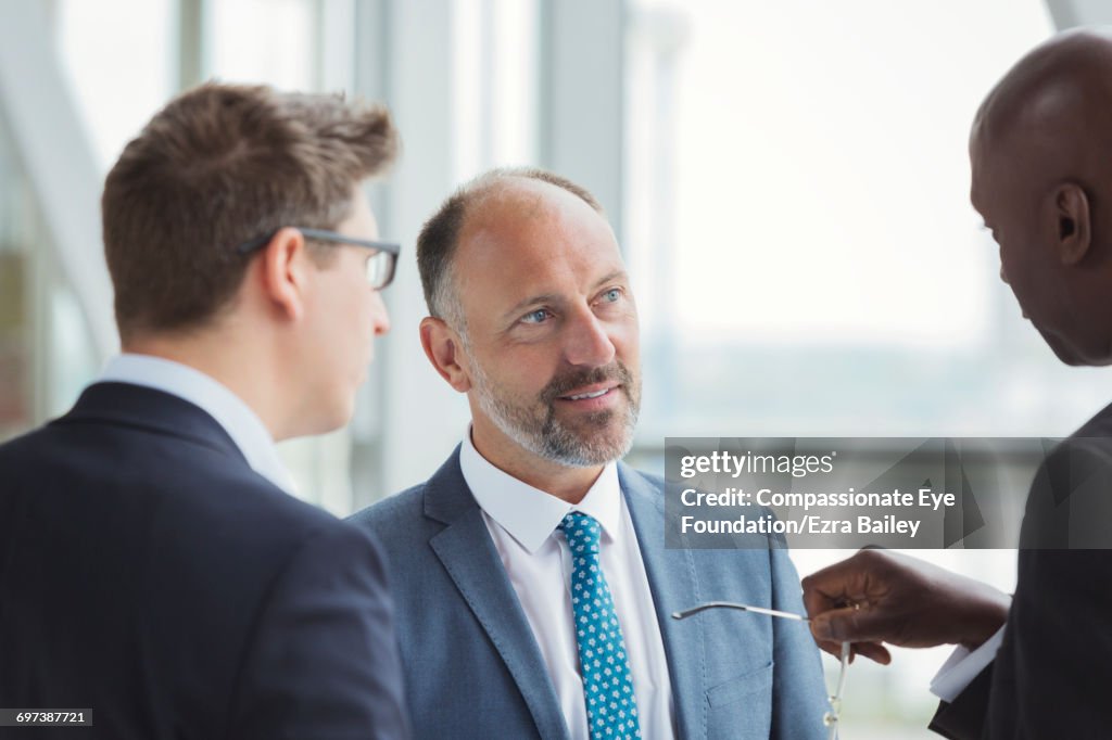 Businessmen discussing plans in modern office