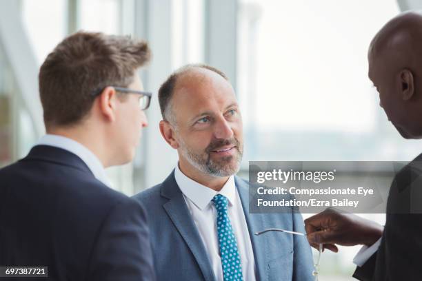 businessmen discussing plans in modern office - full suit stock pictures, royalty-free photos & images