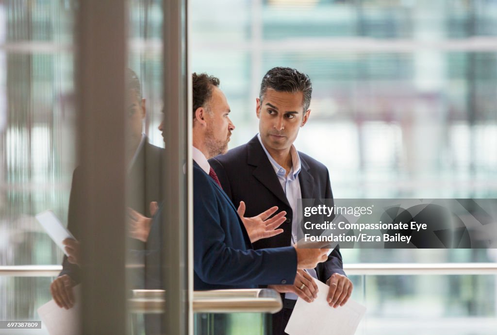 Businessmen discussing project on office balcony