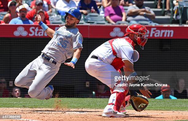 Eric Hosmer of the Kansas City Royals beats the throw to Juan Graterol of the Los Angeles Angels to score a run in the third inning at Angel Stadium...