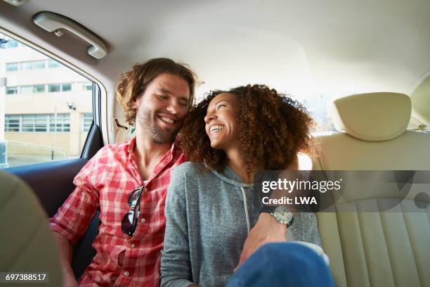 young couple in back seat of car - auto daten stockfoto's en -beelden