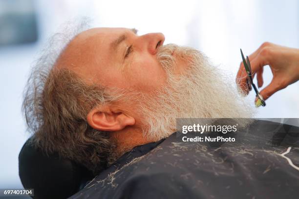 Men are seen being shaved and trimmed during a record holding bear-wearer gathering in Myslecinek park on 18 June, 2017.