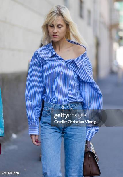 Linda Tol wearing a blue white striped button shirt, denim jeans is seen outside MSGM during Milan Men's Fashion Week Spring/Summer 2018 on June 18,...