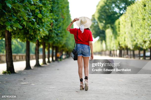 Sarah Benziane, fashion blogger, wears a Naive New Beater red t-shirt with the printed inscription "A La Folie" and a printed heart, a Pimkie blue...