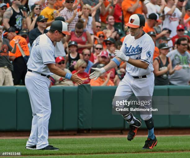 Baltimore Orioles' Seth Smith, right, is congratulated by third base coach Bobby Dickerson, left, as he rounds the bases after his lead off home run...