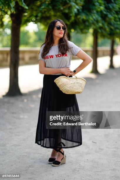 Sarah Benziane, fashion blogger Les Colonnes de Sarah, wears a The Kooples ruffled black skirt, a New Look t-shirt with the printed inscription "New...