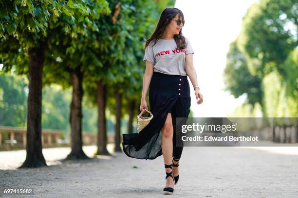 Sarah Benziane, fashion blogger Les Colonnes de Sarah, wears a The Kooples ruffled black skirt, a New Look t-shirt with the printed inscription "New...