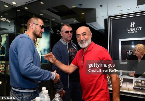 Boxing trainer Egis Klimas looks on as boxer and Hublot ambassador Sergey Kovalev greets a fan during their visit to the Hublot Boutique at The Forum...