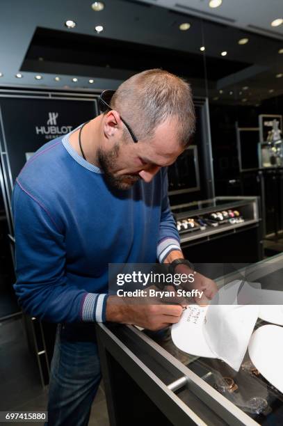 Boxer and Hublot ambassador Sergey Kovalev autographs Hublot baseball hats during his visit to the Hublot Boutique at The Forum Shops at Caesars on...