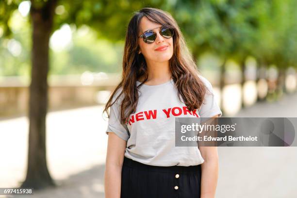 Sarah Benziane, fashion blogger Les Colonnes de Sarah, wears a The Kooples ruffled black skirt, a New Look t-shirt with the printed inscription "New...