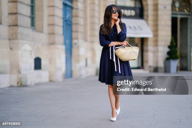 Sarah Benziane, fashion blogger, wears an El Ganso ruffled dress with a belt, a basket made of straw, sunglasses, and Zara white shoes, on June 17,...