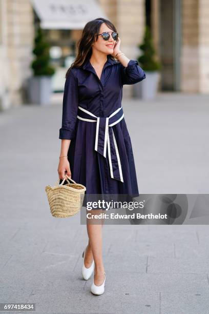 Sarah Benziane, fashion blogger, wears an El Ganso ruffled dress with a belt, a basket made of straw, sunglasses, and Zara white shoes, on June 17,...