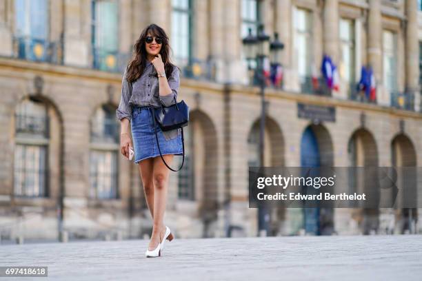 Sarah Benziane, fashion blogger, wears a The Kooples gingham shirt, a New Look blue denim skirt, an Ali Express bag, sunglasses, and Zara white...