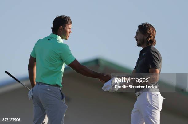 Brooks Koepka of the United States and Tommy Fleetwood of England shake hands after finishing on the 18th green during the final round of the 2017...