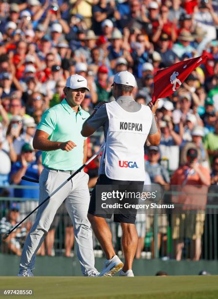 Brooks Koepka of the United States and caddie Richard Elliott react after finishing on the 18th green during the final round of the 2017 U.S. Open at...