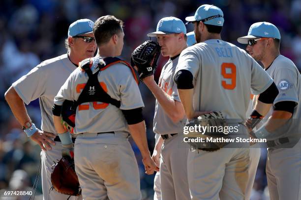 Pitcher Mark Melancon of the San Francisco Giants confers with pitching coach Dave Righetti and Buster Posey in the ninth inning against the Colorado...