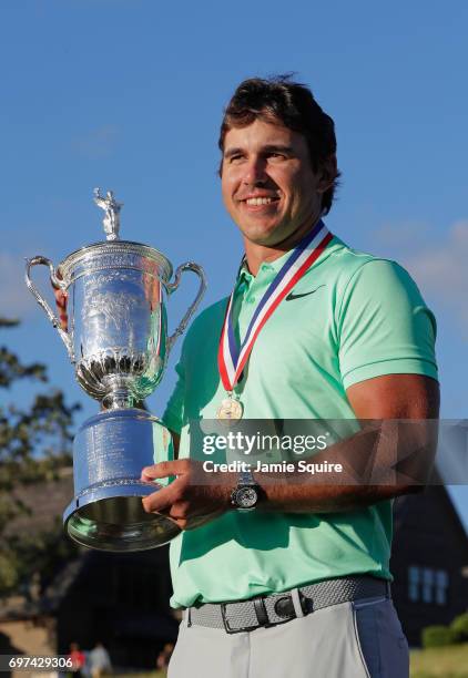 Brooks Koepka of the United States poses with the winner's trophy after his victory at the 2017 U.S. Open at Erin Hills on June 18, 2017 in Hartford,...