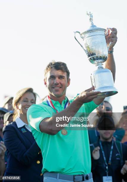 Brooks Koepka of the United States poses with the winner's trophy after his victory at the 2017 U.S. Open at Erin Hills on June 18, 2017 in Hartford,...